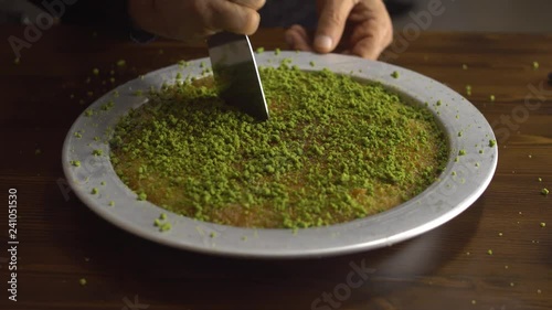 Famous dessert KUNEFE aka KUNEFAH. Cheese with thin pastry cooked, sweetened with sugar syrup, melted saltless cheese dessert from middle east.  photo