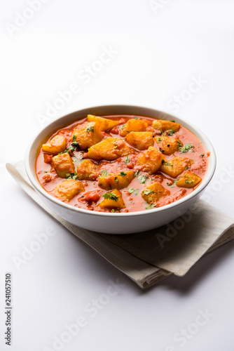 Indian food - Aloo curry masala. Potato cooked with spices and herbs in a tomato curry. served in a bowl over moody background. selective focus © Arundhati