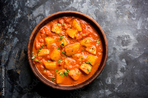 Indian food - Aloo curry masala. Potato cooked with spices and herbs in a tomato curry. served in a bowl over moody background. selective focus photo