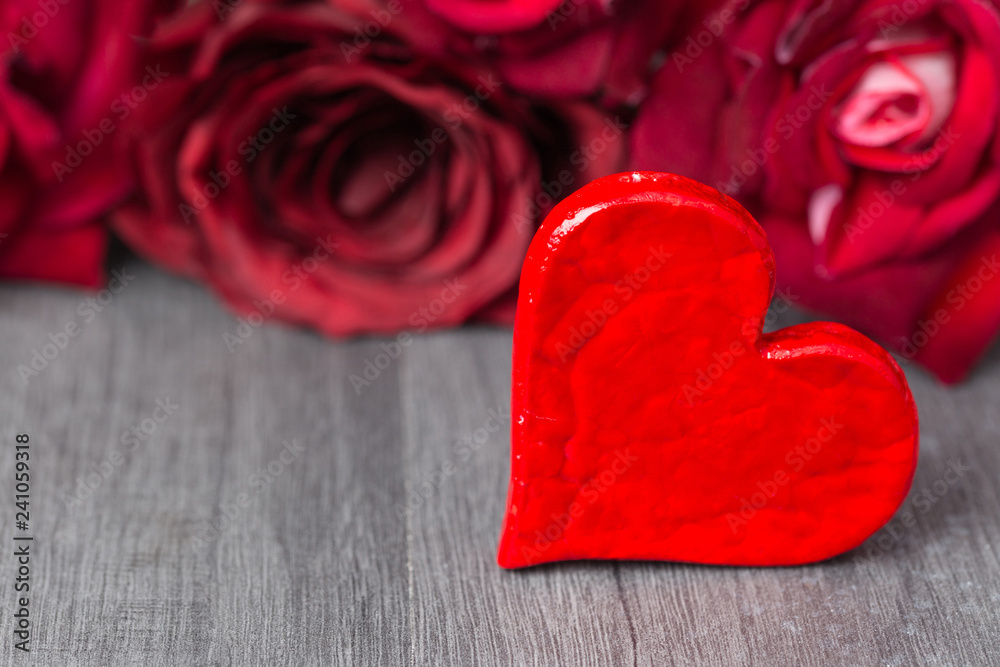 Valentine's Day. Red heart with red rose flowers with copy space on wooden background Valentine's Day. Red heart with red rose flowers with copy space on wooden background