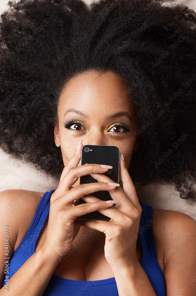 A young woman lying down holding her cellphone A young woman lying down holding her cellphone