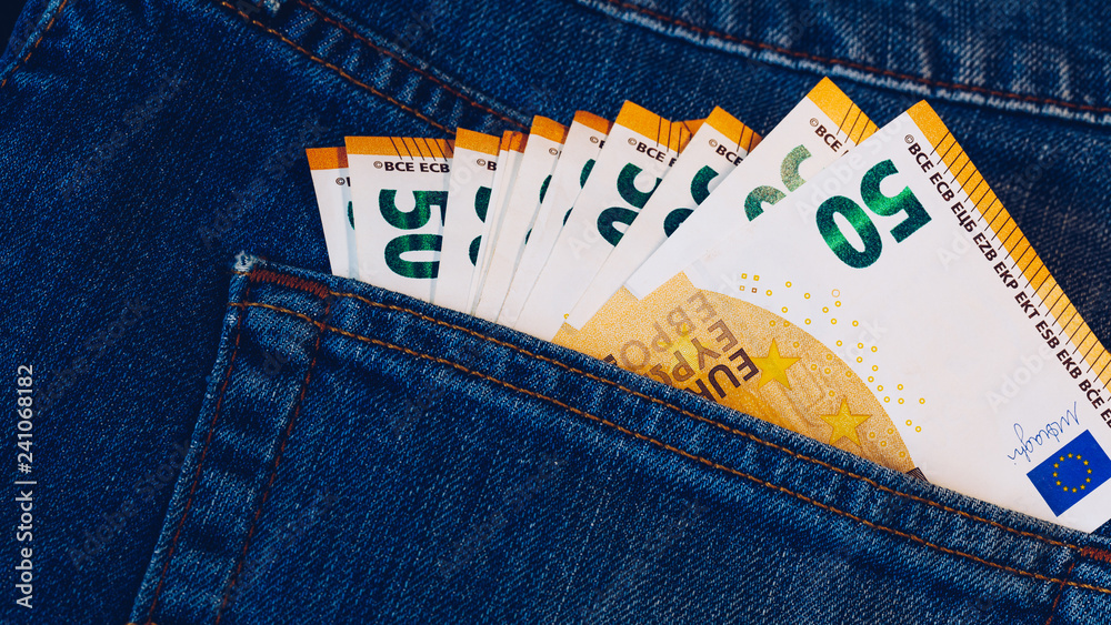 Euro bills in jeans pocket background. Euro banknotes in jeans back pocket.  Concept of rich people, saving or spending money. Euro bills falling out.  Easy to steal the money. Irresponsible action. Stock