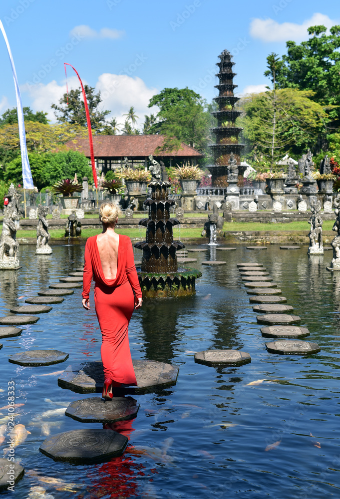 Balinese Water Palace Tirta Gangga, tourist lady in walking on water garden stepping stones, Bali Island, Stock-foto | Adobe Stock