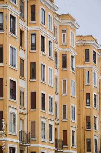 Fachada de edificio amarillo con muchas pequeñas ventanas