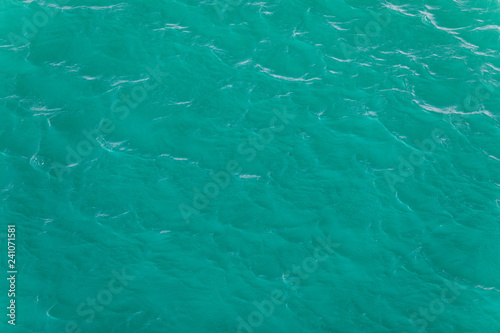 Background shot of aqua sea water surface. Sea surface aerial view. Waving water surface of the sea background.