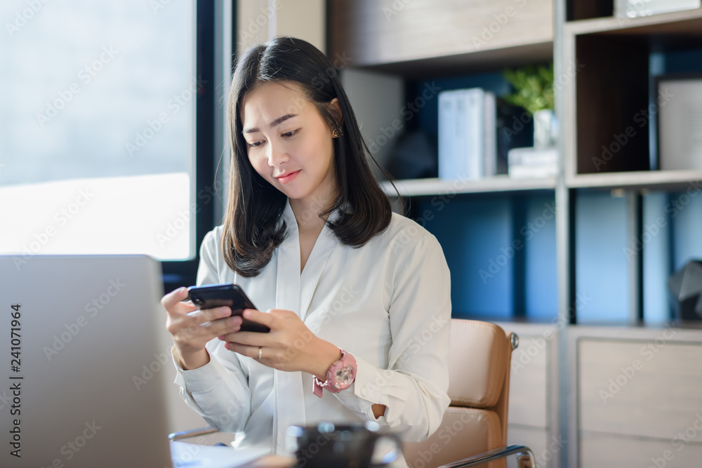 Beautiful Asian businesswoman working in mobile phone chopping At home or modern office Beautiful Asian businesswoman working in mobile phone chopping At home or modern office