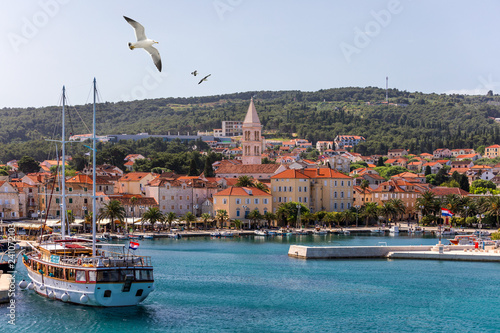 Supetar city in Brac island, Croatia. View from the sea. Picturesque scenic view on Supetar on Brac island, Croatia. Panoramic view on harbor of town Supetar from the side of sea. Brac, Croatia. photo