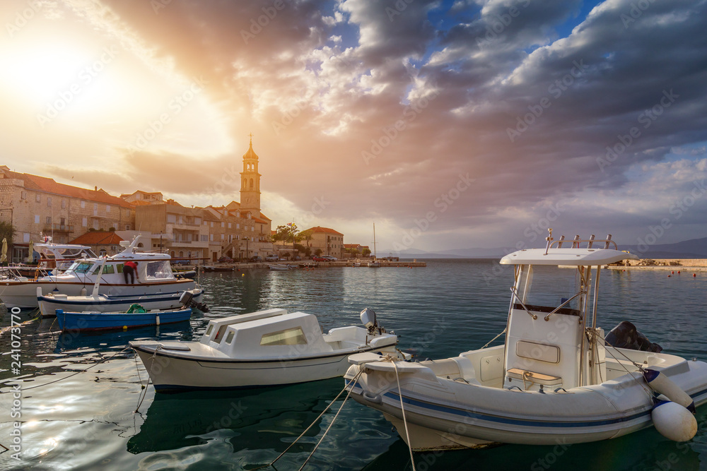 Fototapeta premium Fishing boat anchoring in beautiful Sutivan port, Brac island, Croatia. Sutivan on Island Brac in Croatia. Made of well known white limestone. Port with fishing boats. Sutivan, Brac, Croatia.