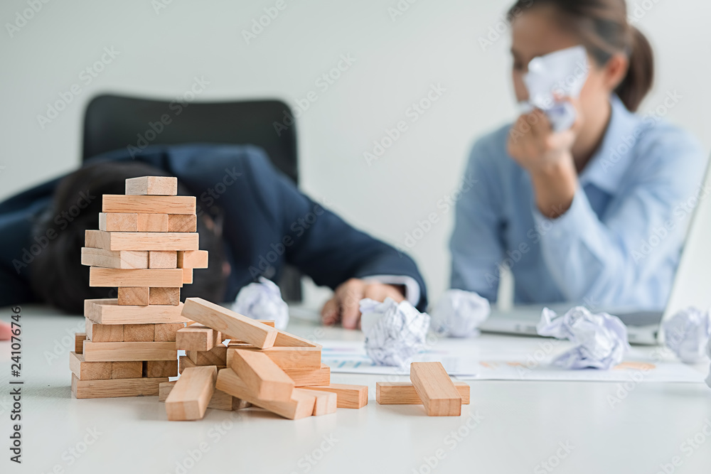 Problem Solving Business can't stop effect of dominoes continuous toppled with business team feeling sad and stress in office background. Failure Business Concept. Problem Solving Business can't stop effect of dominoes continuous toppled with business team feeling sad and stress in office background. Failure Business Concept.
