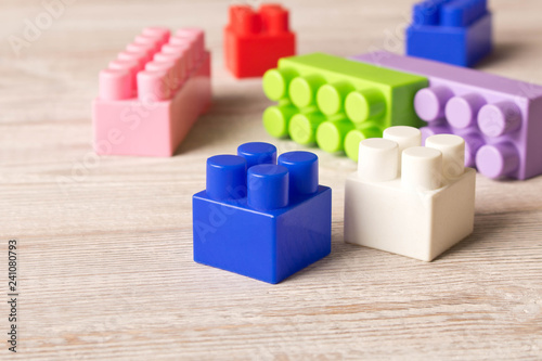 Multi-colored plastic construction set on the wooden table . Children's educational games. Close up