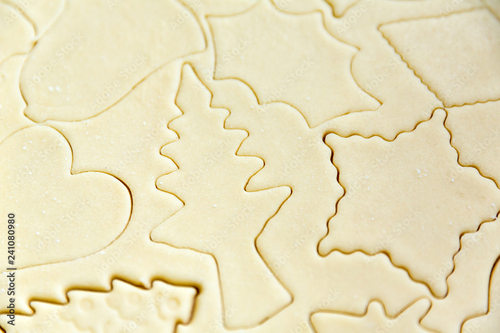 Homemade cookie dough shaped by cutters on a counter Homemade cookie dough shaped by cutters on a counter