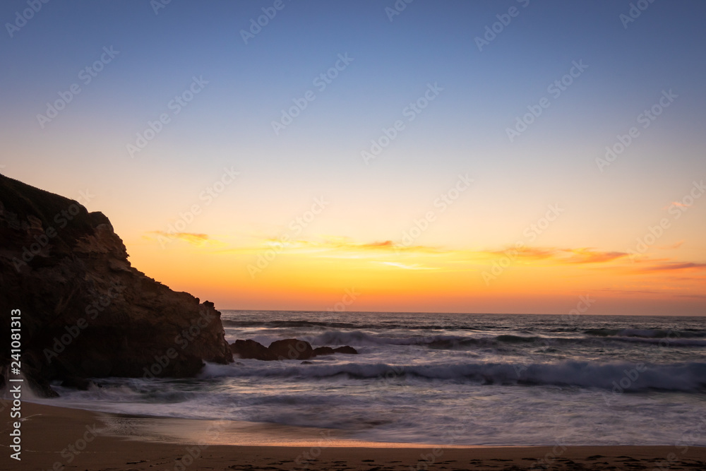 Crashing waves of Miramar Beach at sunset