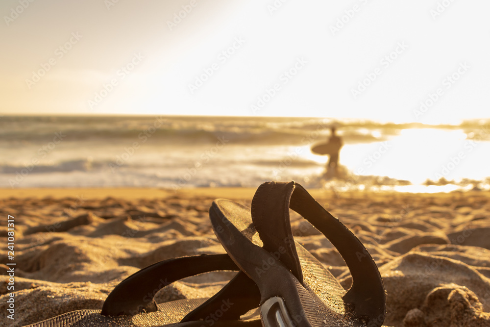 Flip Flops on a sandy beach at sunset