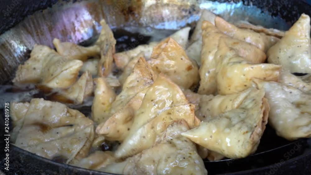 Street trade food : cooking vegetarian samosa on the street market in Udaipur, Rajasthan, India. Indian chef making samosa. Close up Street trade food : cooking vegetarian samosa on the street market in Udaipur, Rajasthan, India. Indian chef making samosa. Close up