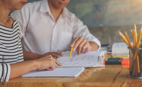 Education concept. Students studying and brainstorming campus concept. Close up of students discussing their subject on books textbooks and writing to notebook.