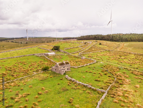Abandoned Irish Farm House and Wind Turbines photo