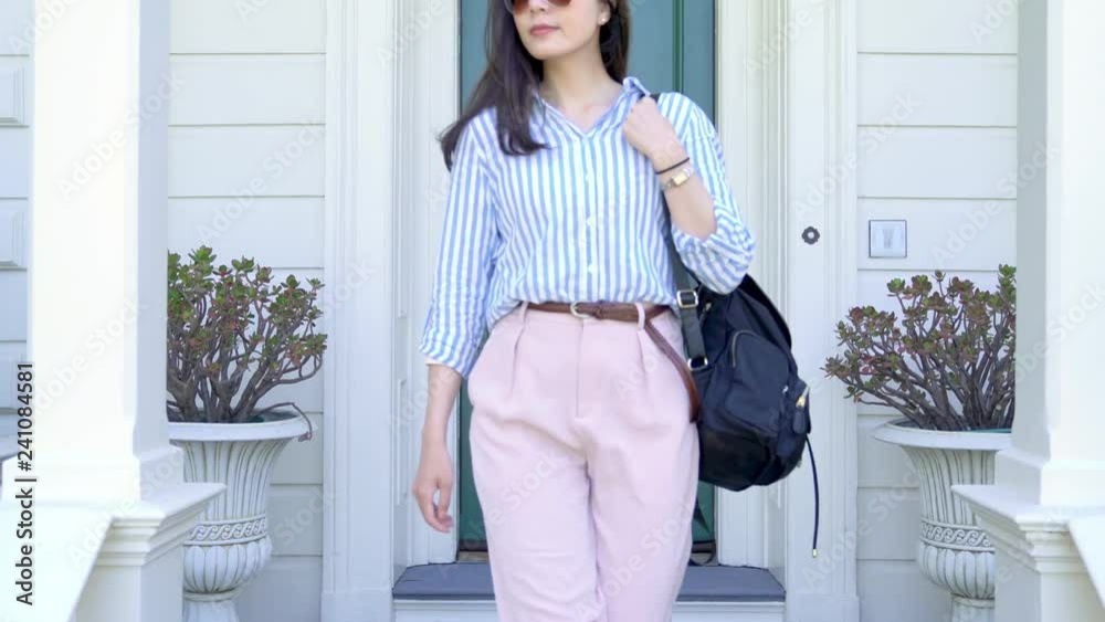 asian woman leaving home to work and locking door of the apartment. white house with green front door traditional house design. beautiful lady going out security safety lock concept.