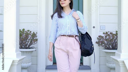 asian woman leaving home to work and locking door of the apartment. white house with green front door traditional house design. beautiful lady going out security safety lock concept.