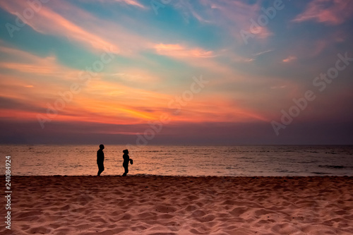 silhouette couple walking on beach, sun set, twilight, copy space