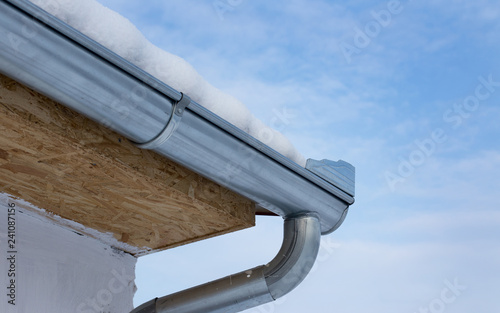 Metal gutter covered with snow