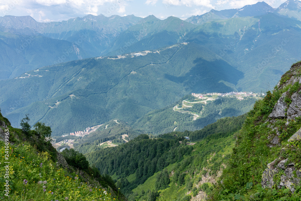 Naklejka premium View from the heights of the Valley from residential houses, surrounded by high mountains. Krasnaya Polyana, Sochi