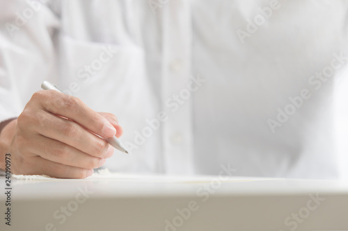 Businessman holding pen on papers