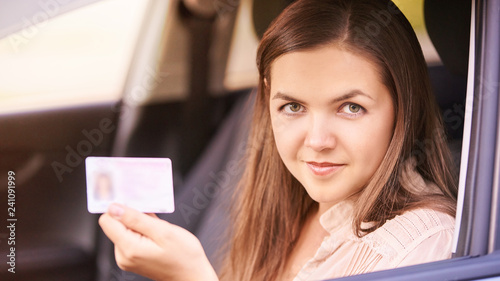 Young woman in car. Ride instruction. Automobile loan photo