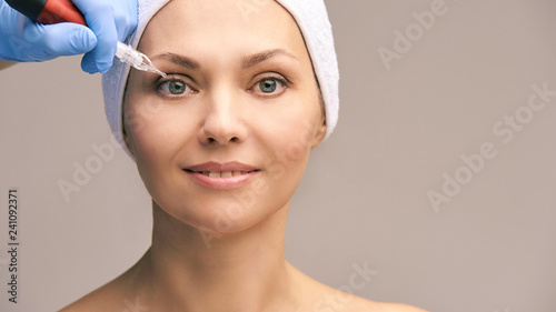 Permanant makeup tattoo. Woman face skin care. Cosmetologist female mikrobleyding photo