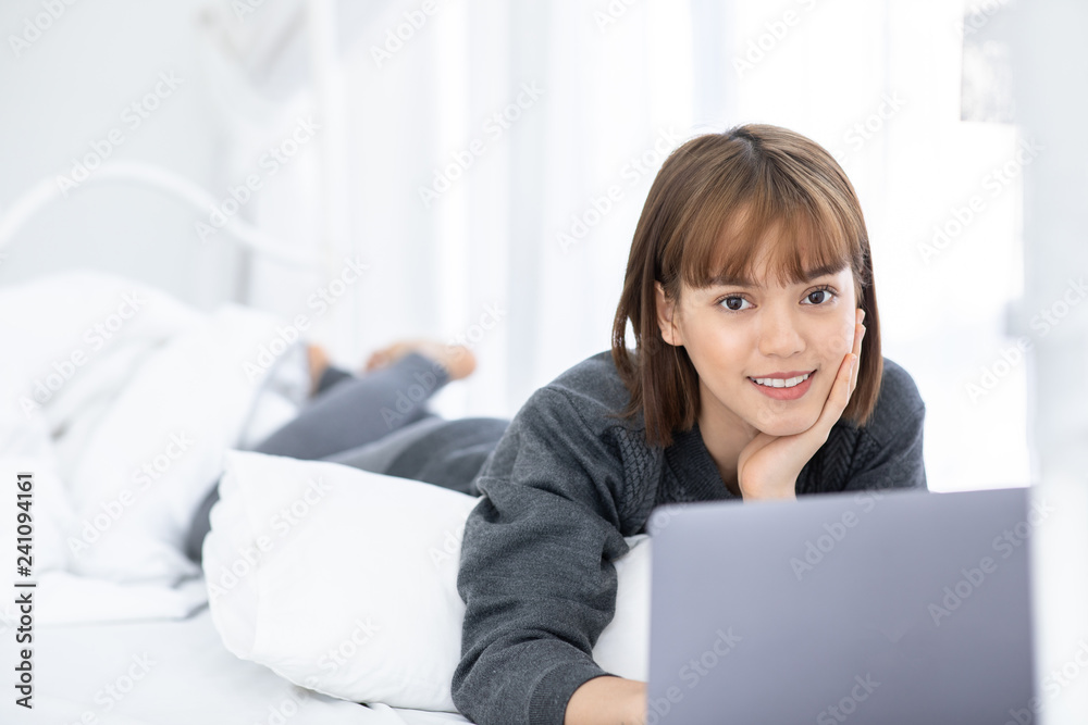 Beautiful Attractive Asian young woman lying on bed and using computer laptop for using social media and shopping online relax in bedroom in holiday,Lifestyle in bedroom Concept Beautiful Attractive Asian young woman lying on bed and using computer laptop for using social media and shopping online relax in bedroom in holiday,Lifestyle in bedroom Concept