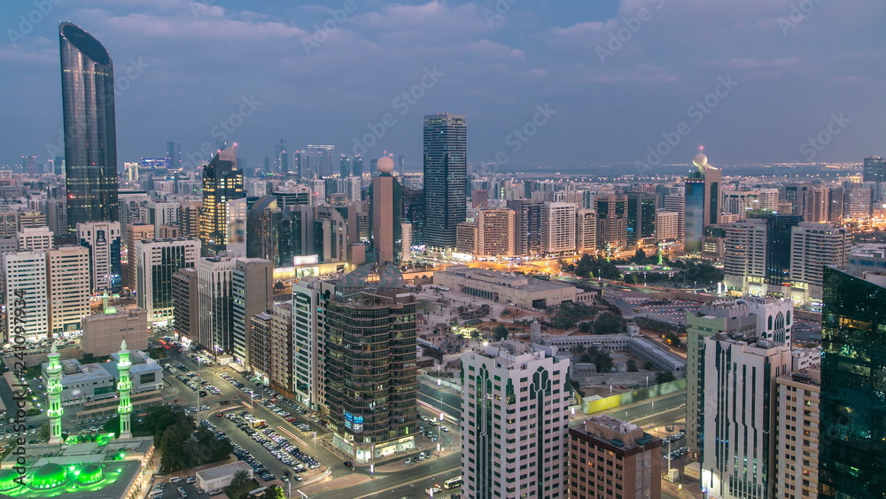 Modern city architecture of Abu Dhabi skyline day to night timelapse, UAE.