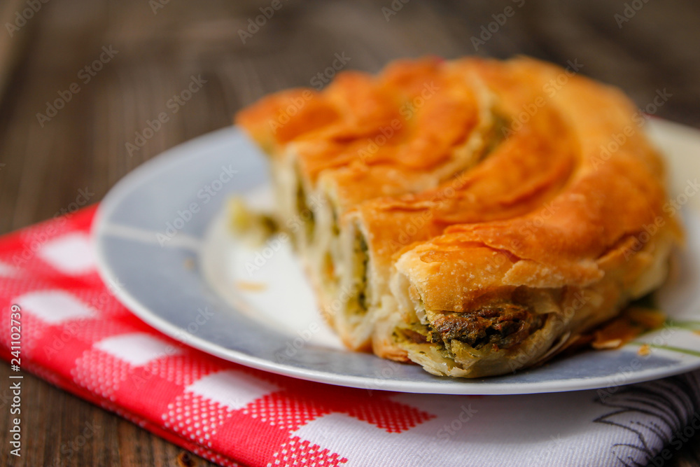 Pastry with cheese and spinach and red dish towel on an retro style wooden table