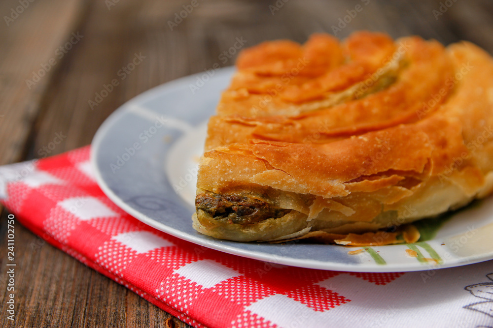 Pastry with cheese and spinach and red dish towel on an retro style wooden table Pastry with cheese and spinach and red dish towel on an retro style wooden table