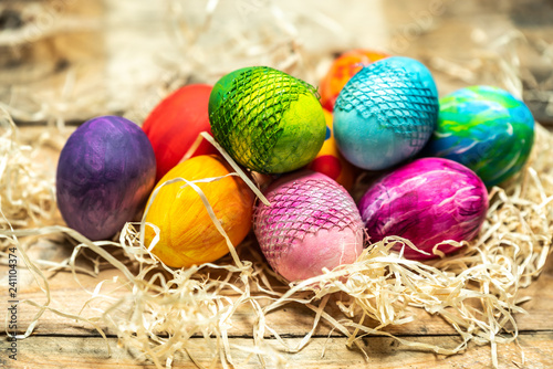 beautiful, bright, very colorful hand-painted eggs on a contrasting, raw, natural background from wooden planks