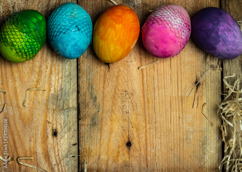 beautiful, bright, very colorful hand-painted eggs on a contrasting, raw, natural background from wooden planks