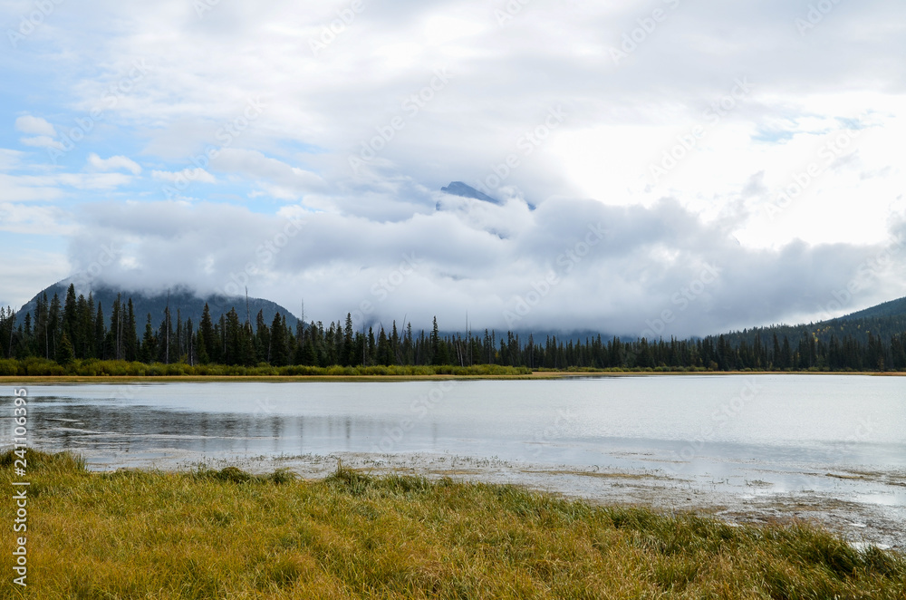 Fototapeta premium 秋のカナディアンロッキー 雨上がりのバーミリオン湖と雲に覆われたランドル山（バンフ国立公園 カナダ・アルバータ州）
