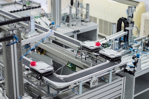 Gripper picks up the product from automated car which is on the manufacturing line in a smart factory. Industry 4.0 concept; artificial intelligence in manufacturing.