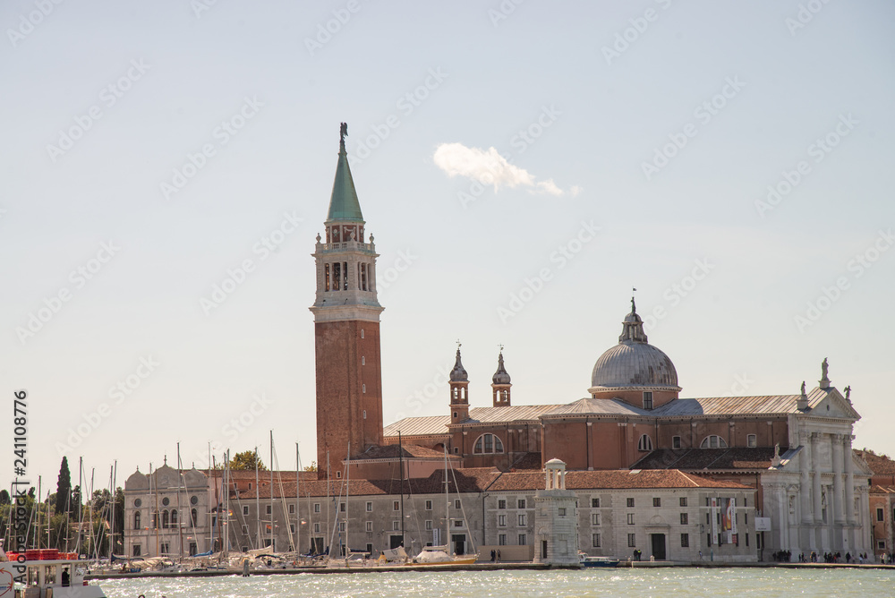 Venice, Italy, island of San Giorgio Maggiore. View from the lagoon of the church of San Giorgio, the marina with sailboats and the lighthouse.