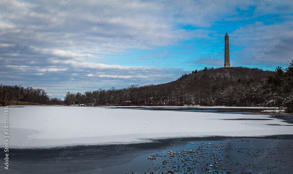 Fototapeta premium High Point Monument at the top of NJ, in winter surrounded by snow and blue skies