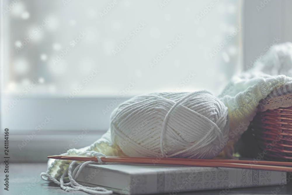 Φωτογραφία Cozy winter home with warm knitted sweaters and ball of yarn near windowsill, home hobbies, vintage tone