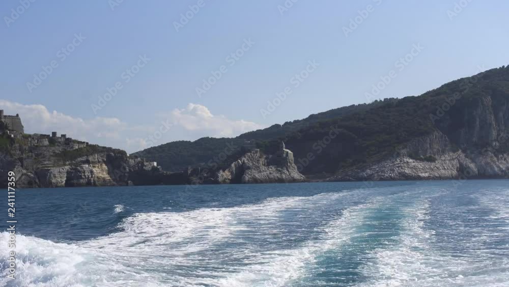 Sailing away from Church of Saint Peter in Cinque Terre Italy. View from the back of motorboat Sailing away from Church of Saint Peter in Cinque Terre Italy. View from the back of motorboat