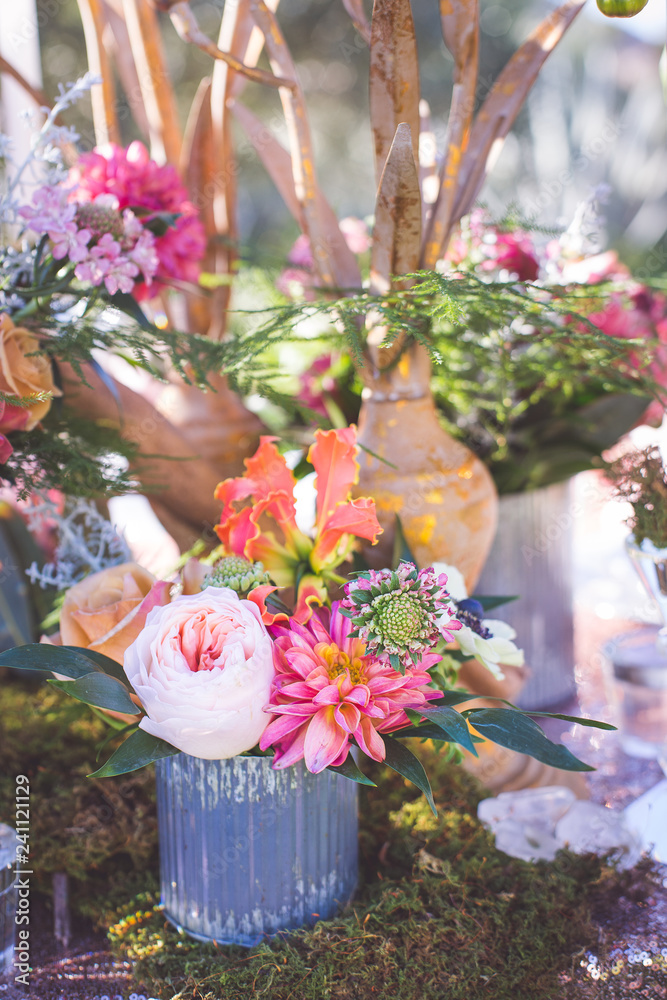 Fototapeta premium pink florals arranged in metal vase with peat moss