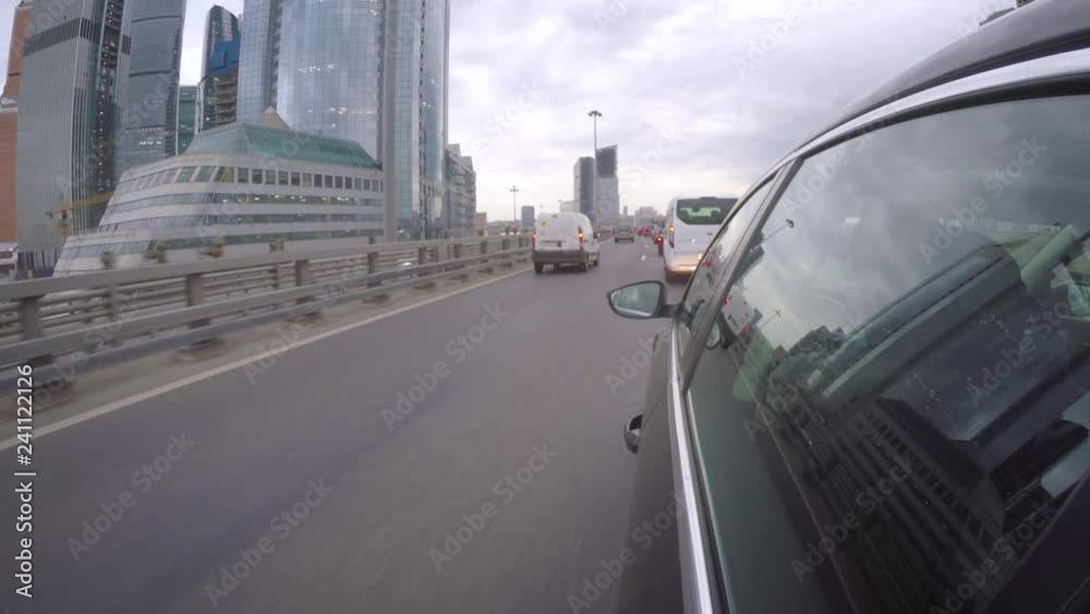 The car moves on the highway in rush hour next to office skyscrapers ...