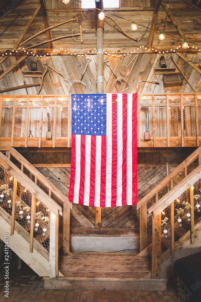 Fotografie usa flag hanging from barn loft