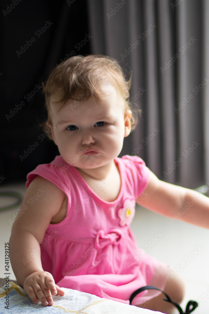 portrait of a distressed 10 month old girl in a pink dress portrait of a distressed 10 month old girl in a pink dress