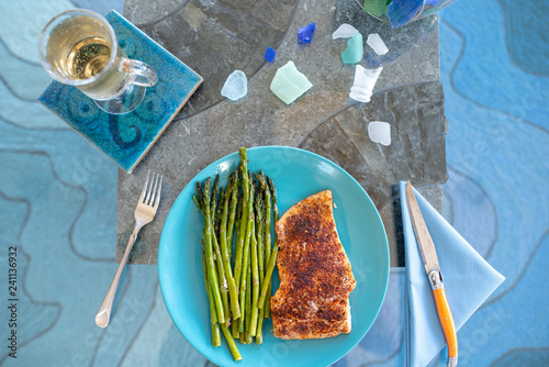 Keto lunch or dinner meal with seasoned cooked salmon, asparagus stalks and a carb-free drink photo