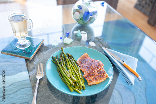 Keto lunch or dinner meal with seasoned cooked salmon, asparagus stalks and a carb-free drink