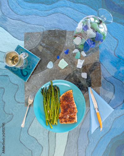 Keto lunch or dinner meal with seasoned cooked salmon, asparagus stalks and a carb-free drink