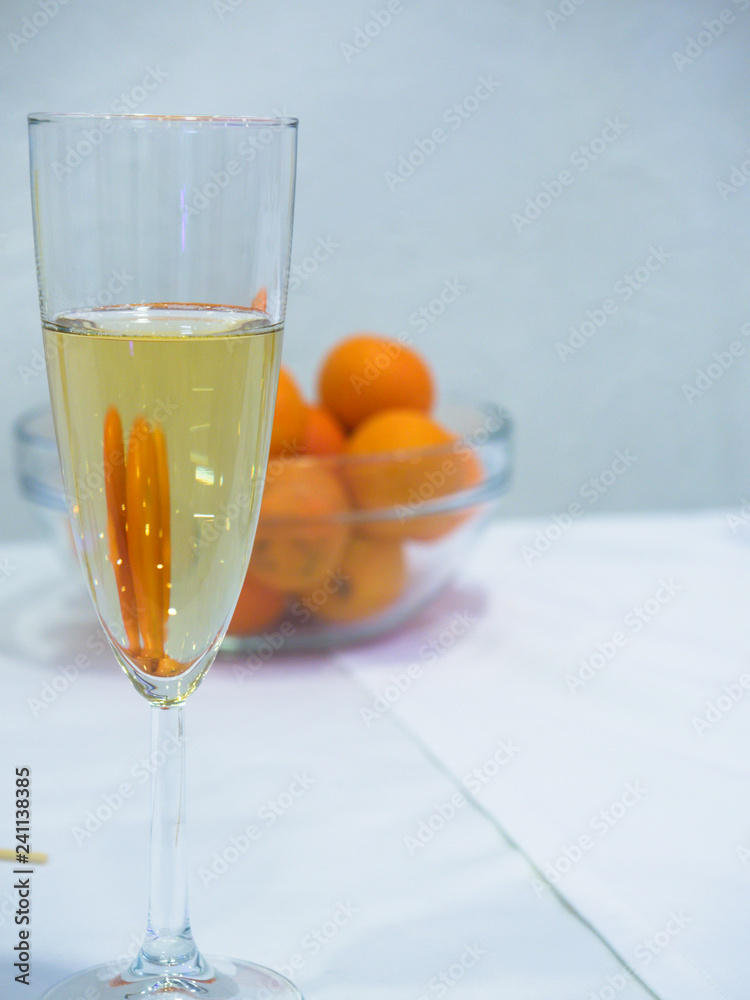 a glass of champagne with a reflection of tangerines