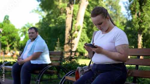 Fat man shy to get acquainted with pretty woman, lady chatting with friend