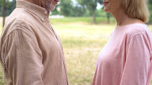 Elderly man and woman looking each other, romantic meeting in countryside, date © motortion